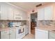 Well-lit kitchen featuring white appliances, gray cabinets, and a tile backsplash at 9051 Sw 96Th Ln # B, Ocala, FL 34481