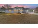 House exterior featuring gray siding, landscaping, and a screened garage at 10628 Sw 74Th Ave, Ocala, FL 34476