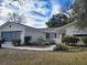 Ranch-style home with attached garage, landscaped yard, and screened porch at 10800 Sw 62Nd Ave, Ocala, FL 34476