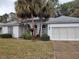 One-story home with grey roof, white exterior, and two palm trees in the front yard at 11577 Sw 72Nd Cir, Ocala, FL 34476