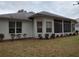 White house exterior with screened porch, landscaping, and spacious backyard at 11577 Sw 72Nd Cir, Ocala, FL 34476