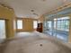 Spacious main bedroom with carpet flooring, ceiling fan, and sliding doors leading to a sunroom at 11577 Sw 72Nd Cir, Ocala, FL 34476