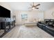 Living room with sectional sofa, dog kennel, and large TV at 12 Pine Trace Pl, Ocala, FL 34472