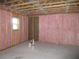 Spacious unfinished basement with pink insulation ready for customization; features a window for natural light at 13055 Ne 7Th Loop, Silver Springs, FL 34488