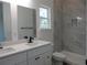 This bathroom boasts dual sinks, modern fixtures, a walk in shower, and a large window for natural light at 13055 Ne 7Th Loop, Silver Springs, FL 34488