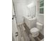 Bathroom with double vanity, grey vinyl plank flooring, and a toilet at 13055 Ne 7Th Loop, Silver Springs, FL 34488