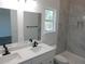 This bright bathroom boasts dual sinks, a walk in shower, and a large window for natural light at 13055 Ne 7Th Loop, Silver Springs, FL 34488