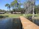 Scenic view of a wooden dock extending into a serene lake with a community picnic area and playground nearby at 13055 Ne 7Th Loop, Silver Springs, FL 34488