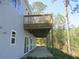 This image captures the home's outdoor wooden deck with a cozy patio area beneath, perfect for relaxation at 13055 Ne 7Th Loop, Silver Springs, FL 34488