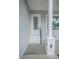 Modern house entrance with white steps, gray siding, and a glass-paned door at 13055 Ne 7Th Loop, Silver Springs, FL 34488