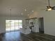 Modern open-concept kitchen with white cabinetry, island sink, and scenic lake view through sliding glass doors at 13055 Ne 7Th Loop, Silver Springs, FL 34488