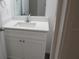 Bathroom vanity with white countertop, white cabinets, modern faucet, and a large mirror at 13099 Ne 7 Loop, Silver Springs, FL 34488