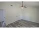 Bedroom with ceiling fan, gray flooring, and door to bathroom at 13099 Ne 7 Loop, Silver Springs, FL 34488