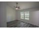 Bright bedroom with ceiling fan, gray flooring, and two windows at 13099 Ne 7 Loop, Silver Springs, FL 34488