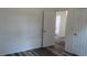 Bedroom with wood-look floors and a view to the bathroom through an open door at 13099 Ne 7 Loop, Silver Springs, FL 34488