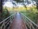 Picturesque boardwalk bridge leads over a serene lake, highlighting the natural beauty at 13099 Ne 7 Loop, Silver Springs, FL 34488