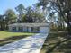 Charming single-story home featuring a gray exterior, black shutters, and a well-manicured lawn at 13099 Ne 7 Loop, Silver Springs, FL 34488