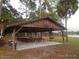 Covered picnic area with tables and benches, set near a lake, ideal for community gatherings at 13099 Ne 7 Loop, Silver Springs, FL 34488