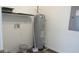 Compact utility room with water heater, shelving, and electric panel at 13099 Ne 7 Loop, Silver Springs, FL 34488