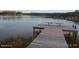 Scenic waterfront view with a rustic wooden dock extending into the calm, serene lake at 13099 Ne 7 Loop, Silver Springs, FL 34488