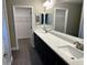 Modern bathroom with double vanity and a large mirror at 13380 Se 43Rd Ave, Belleview, FL 34420