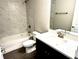 Clean bathroom with white tile, bathtub, and dark vanity at 13380 Se 43Rd Ave, Belleview, FL 34420