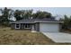 Newly constructed one-story home with a gray exterior and a two-car garage at 13380 Se 43Rd Ave, Belleview, FL 34420