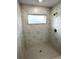 Large walk-in shower with marble-look tile and a bench at 13380 Se 43Rd Ave, Belleview, FL 34420