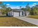 New construction home with a white exterior, gray roof and a long driveway at 14363 Se 36Th Ct, Summerfield, FL 34491