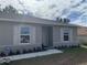 Gray house with white shutters, landscaping, and a walkway to the front door at 15155 Sw 52 Cir, Ocala, FL 34473