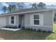 Gray house with white shutters, landscaping, and a small front yard at 15155 Sw 52 Cir, Ocala, FL 34473