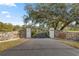 Long paved driveway leading to a gated estate at 15315 Nw 115Th Ct, Reddick, FL 32686