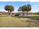 Ranch style home with palm trees and a grassy yard at 15315 Nw 115Th Ct, Reddick, FL 32686