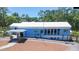 Blue building with white trim, surrounded by lush greenery at 18300 Sw 69 Loop, Dunnellon, FL 34432