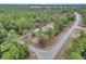 Aerial view of a house nestled in a wooded area with a long driveway at 18300 Sw 69 Loop, Dunnellon, FL 34432