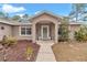 House entrance with a covered porch, landscaping, and walkway at 18300 Sw 69 Loop, Dunnellon, FL 34432