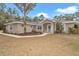 Single-story house with a light brown exterior, landscaping, and walkway at 18300 Sw 69 Loop, Dunnellon, FL 34432