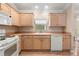 Kitchen features white appliances and wood cabinets at 1982 Somerset Ave, The Villages, FL 32162