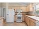 White appliances and light wood cabinets in kitchen at 1982 Somerset Ave, The Villages, FL 32162