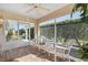 Screened porch with wicker furniture and view of backyard at 1982 Somerset Ave, The Villages, FL 32162