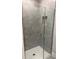 Modern shower featuring gray tiling, glass doors, a white shower base, and integrated shelves at 2158 Nw 23Rd Loop, Ocala, FL 34475
