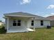 Home's backyard featuring a covered porch, a well-maintained lawn, and a sliding glass door at 2162 Nw 23Rd Loop, Ocala, FL 34475