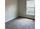 Bedroom with neutral walls, carpet floors, and a window with a view of the outdoors at 2162 Nw 23Rd Loop, Ocala, FL 34475