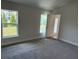 Carpeted bedroom featuring two windows for natural light and a door to an outside patio at 2162 Nw 23Rd Loop, Ocala, FL 34475