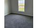 Bedroom with neutral walls, carpet floors, and a window with a view of the outdoors at 2162 Nw 23Rd Loop, Ocala, FL 34475