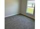 Bedroom with neutral walls, carpet floors, and a window with a view of the outdoors at 2162 Nw 23Rd Loop, Ocala, FL 34475