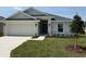 Charming single-Gathering home featuring a two-car garage, a well-maintained lawn, and a covered front entryway at 2162 Nw 23Rd Loop, Ocala, FL 34475