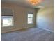 Bright bedroom with neutral carpeting and two windows at 2418 Ne 7Th St # 9, Ocala, FL 34470