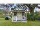 Charming white playhouse with green trim and fenced yard at 2883 Sw 66Th St, Ocala, FL 34476