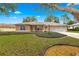 Tan one-story house with mature landscaping and a large yard at 6151 Sw 84Th St, Ocala, FL 34476